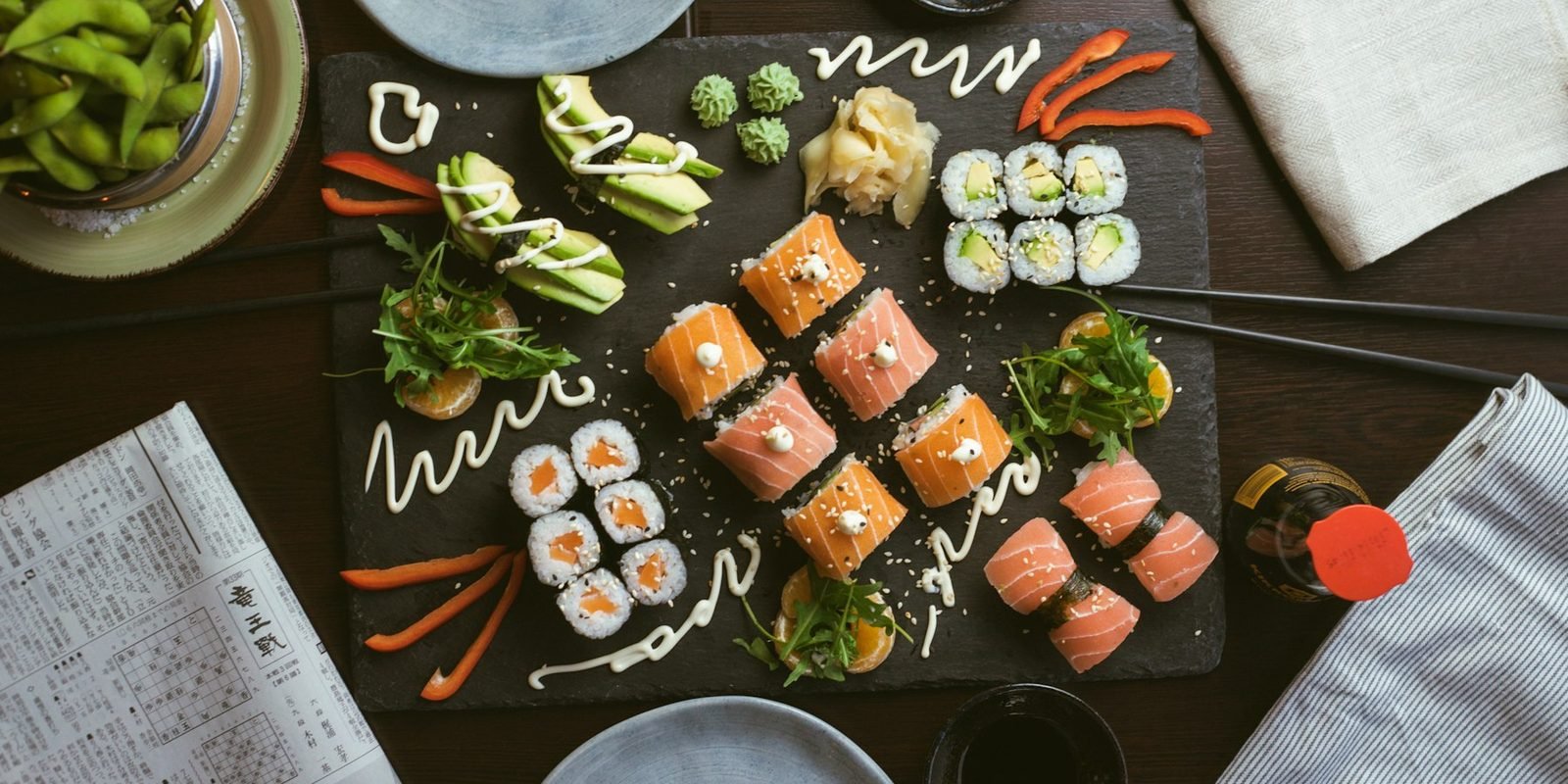 A table spread with sushi rolls, nigiri and small plates